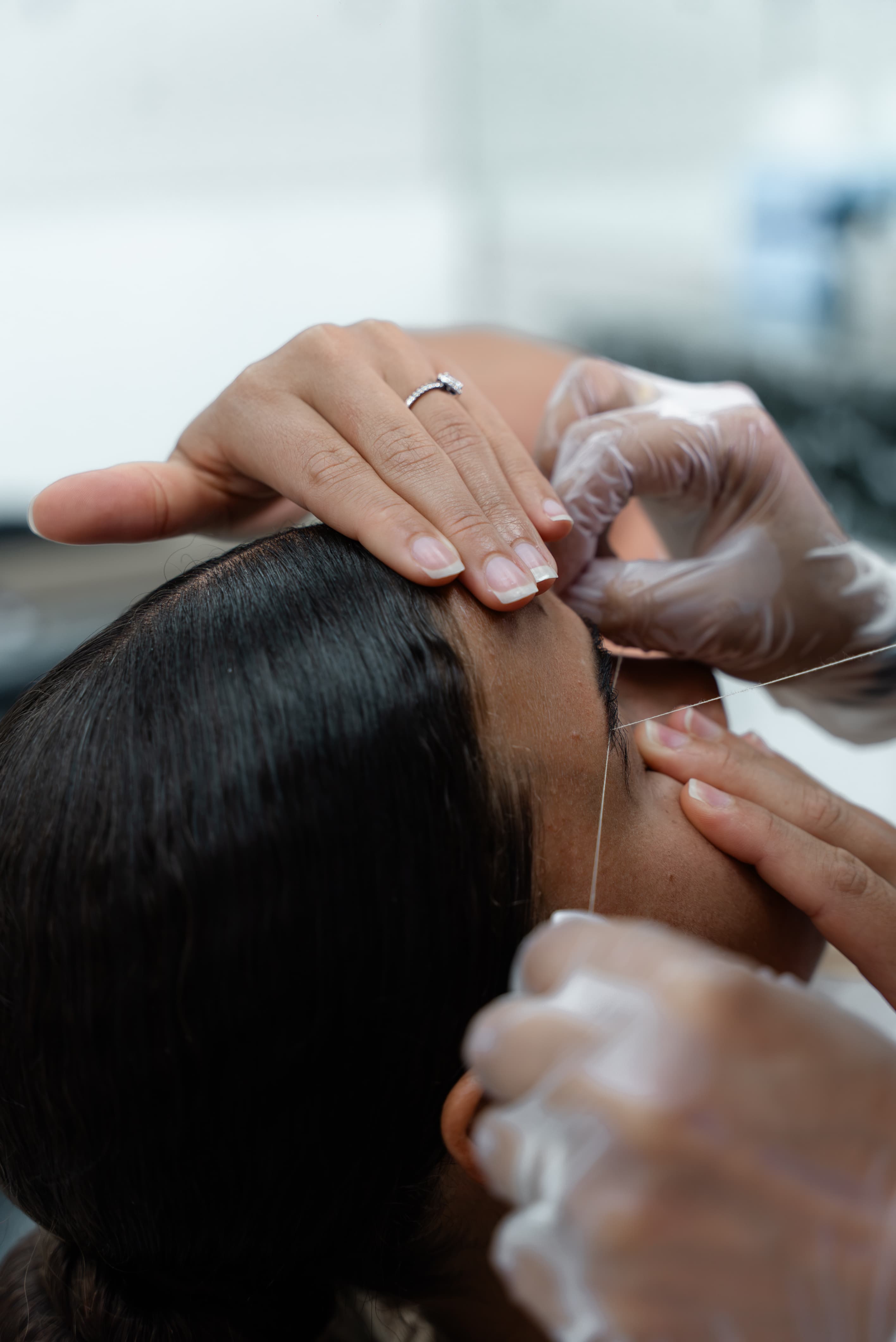 Eyebrow threading close-up — precision thread technique at UniqSwek